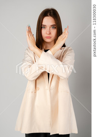 Young Woman Standing With Arms Crossed on gray background Young Woman Standing With Arms Crossed on gray background 118300030