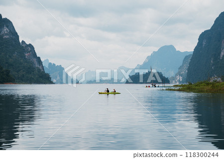 Kayakers glide across serene waters in Khao Sok National Park, Thailand on a cloudy day 118300244