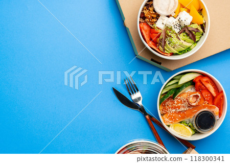 Different poke bowls on blue background top view 118300341