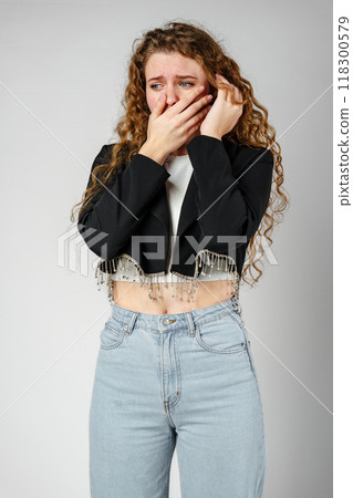 Young Woman Covering Face With Hands in Studio 118300579