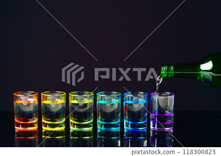Colorful small glasses on black background with alcohol drink Colorful small glasses on black background with alcohol drink 118300823
