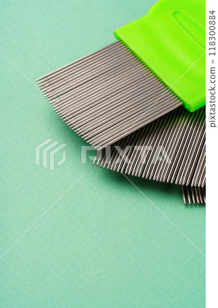 Three combs for lice removing on green background 118300884