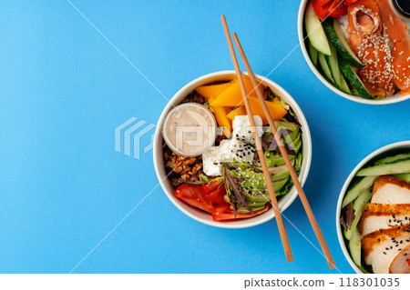 Different poke bowls on blue background top view 118301035