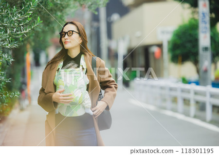 一位母親抱著嬰兒行走 一位母親抱著嬰兒行走 118301195