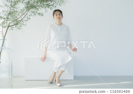 Middle-aged woman in a white dress Middle-aged woman in a white dress 118301489