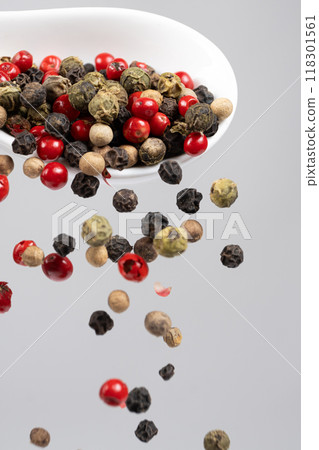 Different types of peppercorns pouring. Red, green, white and black pepper. 118301561