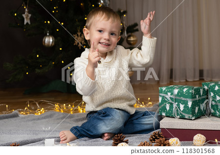 Little two-year-old boy opens Christmas gifts at home 118301568