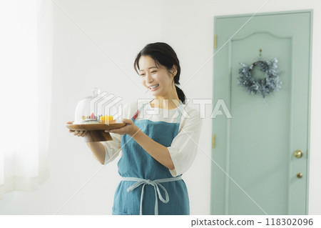 一個穿著圍裙的女人拿著糖果 118302096