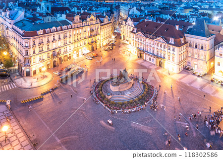 As evening falls, Old Town Square in Prague comes alive with vibrant lights, casting a warm glow on historic buildings and the bustling crowd gathered around the central fountain. As evening falls, Old Town Square in Prague comes alive with vibrant lights, casting a warm glow on historic buildings and the bustling crowd gathered around the central fountain. 118302586
