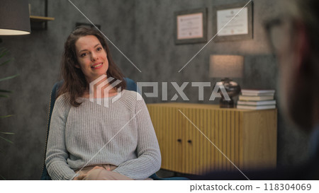 Adult woman sits in chair, discusses problems with psychologist, finds solution on counseling session Adult woman sits in chair, discusses problems with psychologist, finds solution on counseling session 118304069