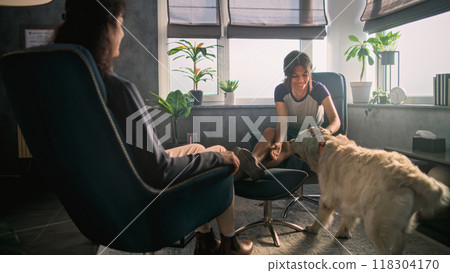 Female psychotherapist listens and supports patient, pets golden retriever dog Female psychotherapist listens and supports patient, pets golden retriever dog 118304170