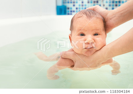 Mother bathing newborn baby in gentle water Mother bathing newborn baby in gentle water 118304184