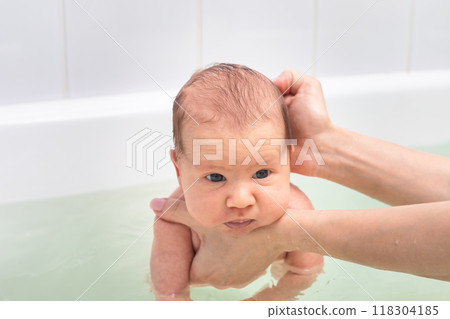 Mother bathing newborn baby in gentle water Mother bathing newborn baby in gentle water 118304185