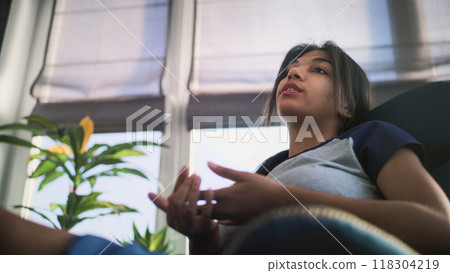 Close up of African American teenage girl sitting and talking with psychologist 118304219