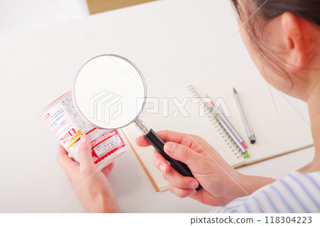一位女士正在檢查方便食品的成分 一位女士正在檢查方便食品的成分 118304223