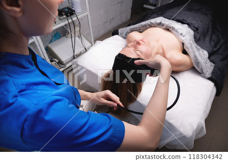 Close-up of massage device in cosmetology room. Lymphatic drainage massage for middle-aged Caucasian white woman 118304342