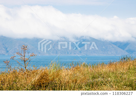 sunburnt grass and cloud on mountain coast of lake sunburnt grass and cloud on mountain coast of lake 118306227