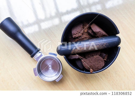 Compacted coffee ground in knock box with portafilter next to it. Coffee grounds are excellent natural and organic fertilizers. Compacted coffee ground in knock box with portafilter next to it. Coffee grounds are excellent natural and organic fertilizers. 118306852