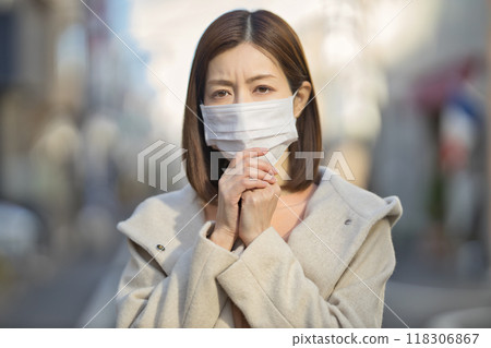 Middle-aged woman walking outdoors wearing a mask Middle-aged woman walking outdoors wearing a mask 118306867