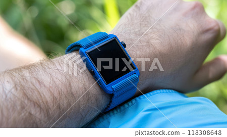 Blue smartwatch on wrist outdoors 118308648