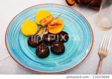 Fried blood sausage morcilla served with baked potatoes 118310689