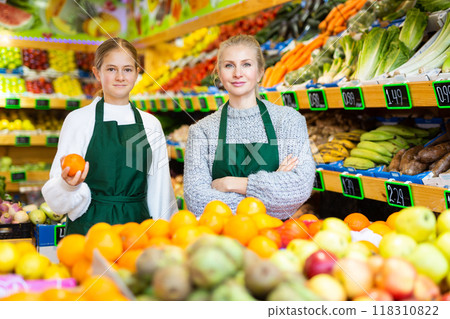 Girl helping her mother work as a salesman in a grocery store 118310822