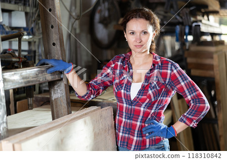 Portrait of confident female worker in workshop of metallurgical plant Portrait of confident female worker in workshop of metallurgical plant 118310842
