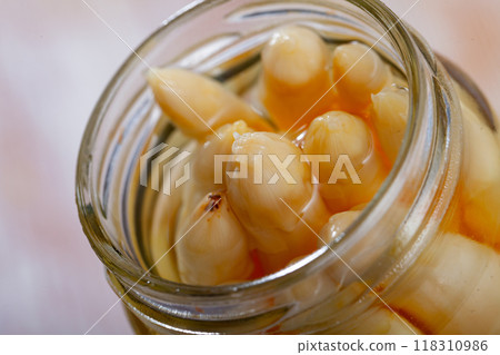 Glass jar with pickled asparagus on a wooden table 118310986