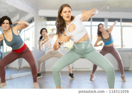 Young female teacher conducts modern hip hop dance lessons for group of girls Young female teacher conducts modern hip hop dance lessons for group of girls 118311056