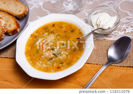Popular dish of Russian cuisine is pickle soup with meat, cooked on basis of pickled cucumbers and pearl barley or rice, decorated with sprig of parsley Popular dish of Russian cuisine is pickle soup with meat, cooked on basis of pickled cucumbers and pearl barley or rice, decorated with sprig of parsley 118311076