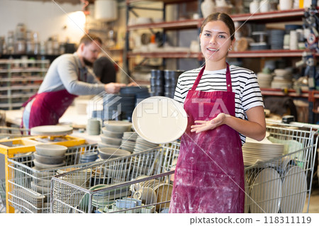 Young woman posing with ceramic dishes Young woman posing with ceramic dishes 118311119