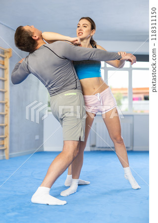 Woman and man practicing self defense techniques 118311150