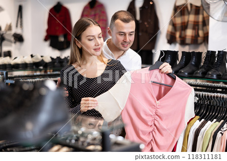 Man with wife participate in inspection of goods, help determine choice of blouse Man with wife participate in inspection of goods, help determine choice of blouse 118311181