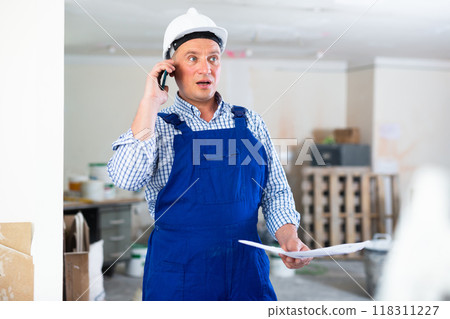 Construction worker having telephone conversation Construction worker having telephone conversation 118311227