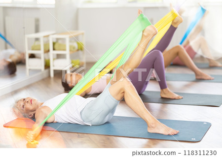 Group of people with working out with rubber bands in gym Group of people with working out with rubber bands in gym 118311230