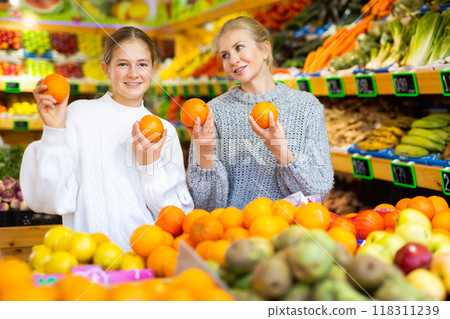 Portrait of teenage girl and mother who buying fresh oranges at grocery shop Portrait of teenage girl and mother who buying fresh oranges at grocery shop 118311239