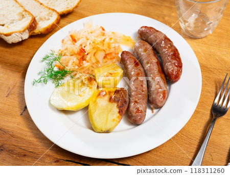 Sausages served with potatoes and cabbage Sausages served with potatoes and cabbage 118311260
