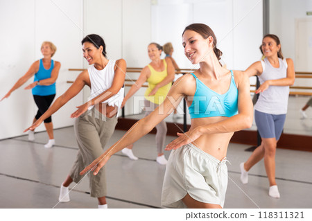 Group of dancers exercising modern dance movements in ball room Group of dancers exercising modern dance movements in ball room 118311321