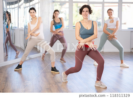 Female teacher conducts modern dance lessons for group of girls Female teacher conducts modern dance lessons for group of girls 118311329