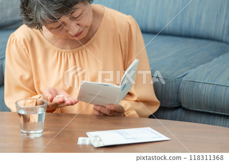 senior woman taking medicine 118311368
