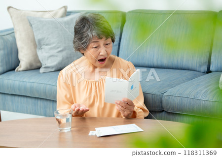 senior woman taking medicine 118311369