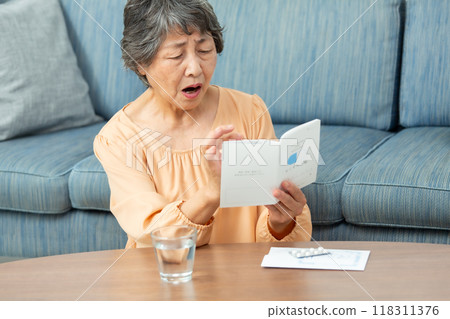senior woman taking medicine 118311376