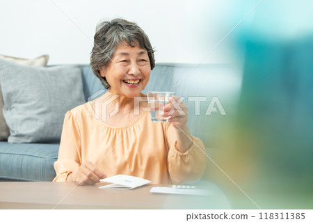 senior woman taking medicine 118311385