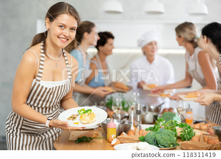 Young woman holding plate with cooked chicken breast Young woman holding plate with cooked chicken breast 118311419