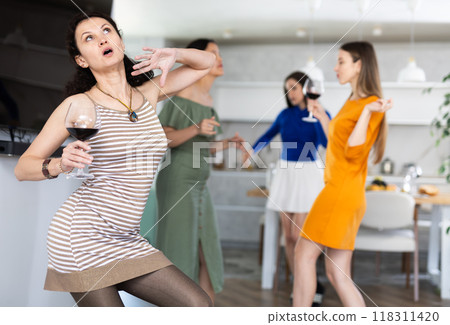 Woman have fun dancing during house party with female friends. 118311420