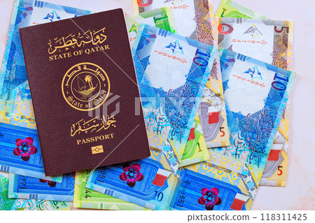 Passport issued by State of Qatar with Qatari banknotes in currency Riyals in cash of various denominations 118311425