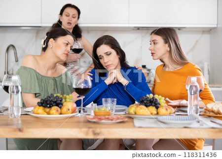 Upset woman shares her problems with her friends. They calm her down Upset woman shares her problems with her friends. They calm her down 118311436