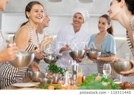 Young woman talks and drinks with group during master class Young woman talks and drinks with group during master class 118311448