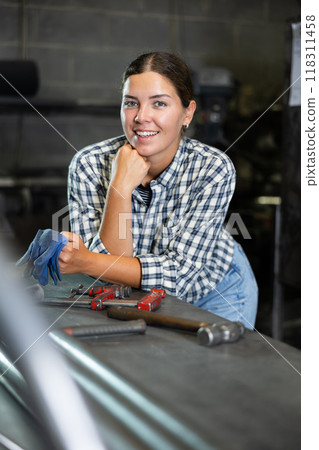 Young woman posing in metallurgical workshop Young woman posing in metallurgical workshop 118311458