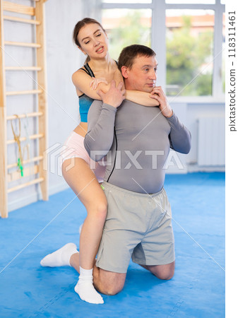 Adult man and young woman training self-defense techniques Adult man and young woman training self-defense techniques 118311461